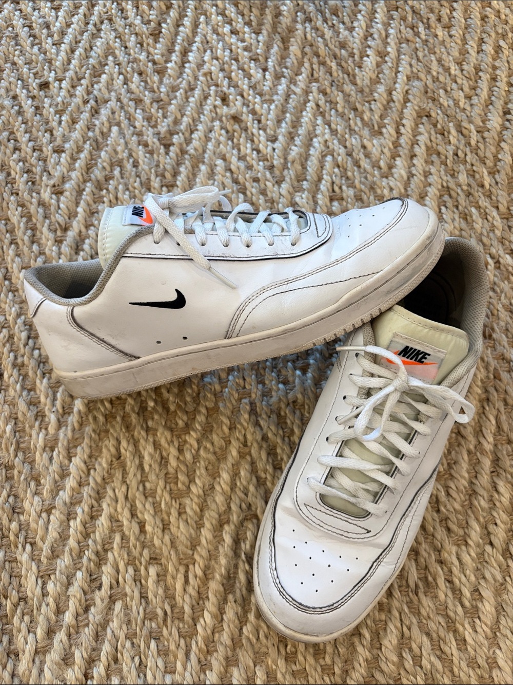 Nike White Low-Top Sneakers with Black Swoosh and Orange Tongue Accent